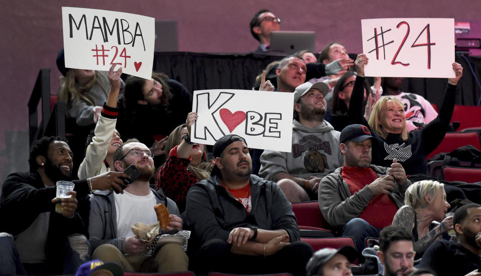 Fans hold up signs in memory of Kobe Bryant, who was killed in a helicopter crash in California, during the second half of an NBA basketball game between the Portland Trail Blazers and the Indiana Pacers in Portland, Ore., Sunday, Jan. 26, 2020. The Blazers won 139-129. (AP Photo/Steve Dykes)