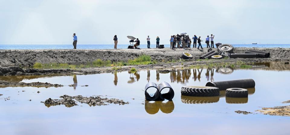 Media wait for California Gov. Gavin Newsom Tuesday, April 25, 2023 at the edge of the flooded Tulare Lake south of the Tule River along Sixth Avenue in Corcoran, Calif.