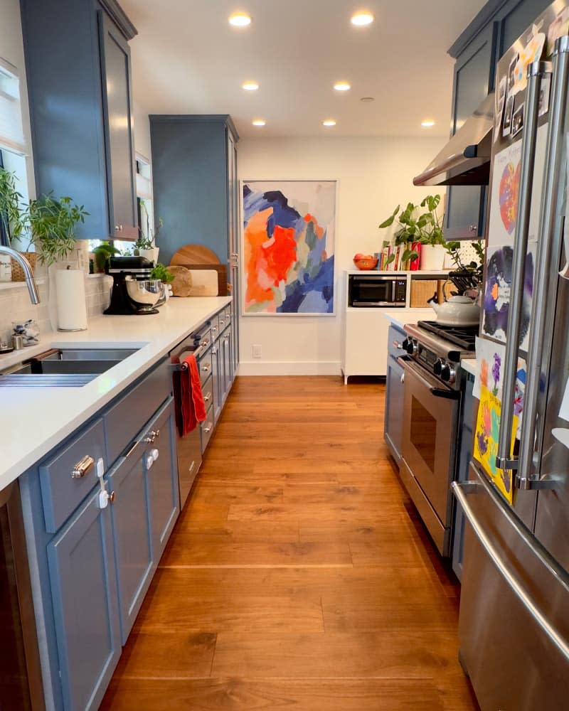 Light countertops in kitchen with blue countertop after renovation.