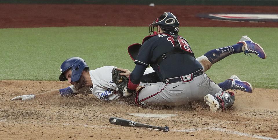 Catcher Travis d'Arnaud tags out Chris Taylor as Taylor tries to slide head first into home plate.