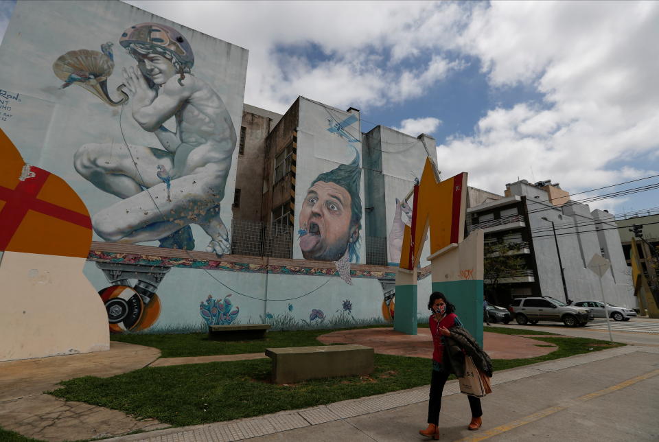 A woman walks past a mural painted by Argentine artist Martin Ron, in Buenos Aires, Argentina September 23, 2021. Picture taken September 23, 2021. REUTERS/Agustin Marcarian