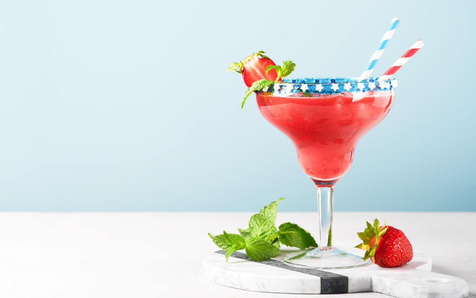 Glass margarita cocktail with strawberry, mint, and red white and blue colors. (Getty Images)