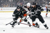 Anaheim Ducks defenseman Josh Mahura, center, is squeezed between Los Angeles Kings defenseman Mikey Anderson, left, and defenseman Drew Doughty during the first period of a preseason NHL hockey game Sunday, Oct. 2, 2022, in Los Angeles. (AP Photo/Mark J. Terrill)