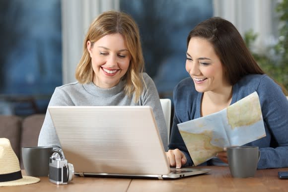 Two women look at a map and a computer