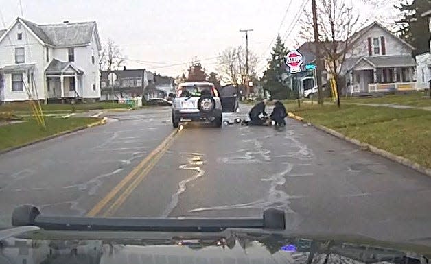 Officer Devin Wireman and Lt. Scott Bursby of the Bucyrus Police Department handcuff the suspect during a Nov. 11 shooting incident in this screen capture from a Bucyrus Police Department video.