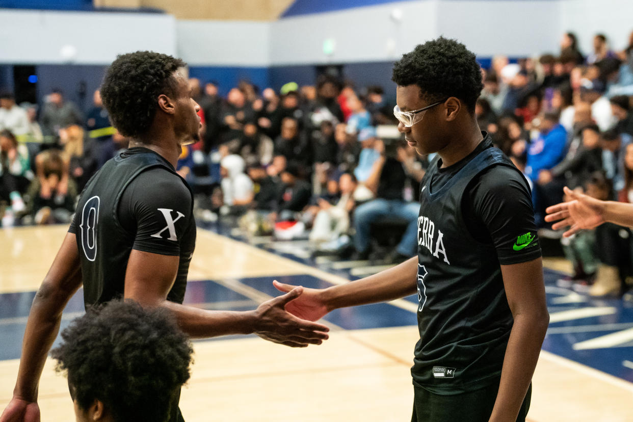 CHATSWORTH, CALIFORNIA - DECEMBER 12: Bronny James high fives brother Bryce James at the Sierra Canyon vs Christ The King boys basketball game at Sierra Canyon High School on December 12, 2022 in Chatsworth, California. (Photo by Cassy Athena/Getty Images)