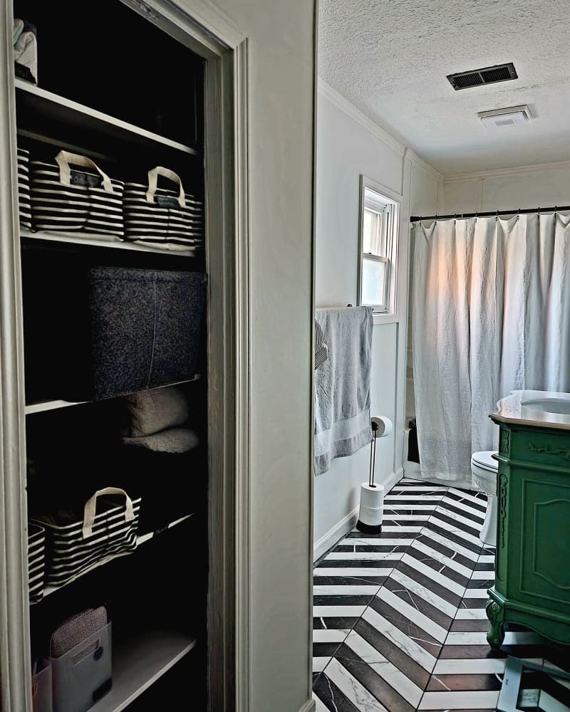 Bathroom with green vanity after renovation.