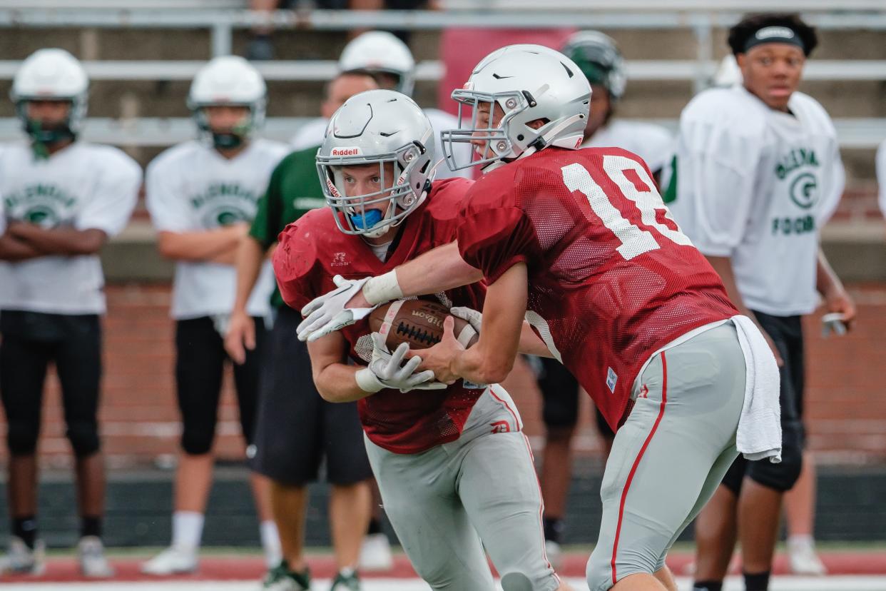 Dover's Mitchell Martin takes the handoff from Ben Hamm during a scrimmage against GlenOak, Saturday, Aug. 6 at Crater Stadium.