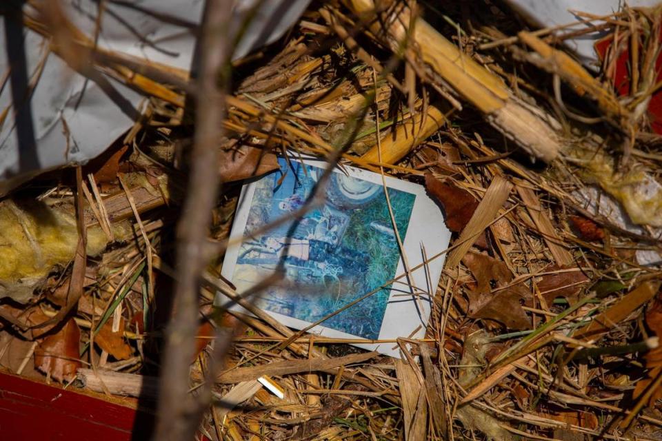 A picture rests with debris along a fence line in Mayfield, Ky., on Sunday, Dec. 12, 2021. A deadly tornado ripped through the region Friday night.
