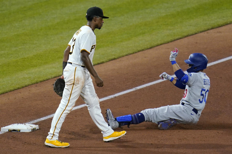 Los Angeles Dodgers' Mookie Betts (50) slides safely into third past Pittsburgh Pirates third baseman Ke'Bryan Hayes with an RBI triple during the fifth inning of a baseball game in Pittsburgh, Tuesday, June 8, 2021. (AP Photo/Gene J. Puskar)