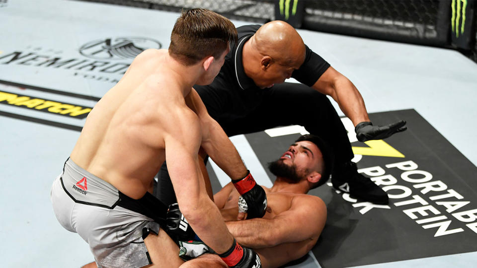 Drew Dober standing over opponent Nasrat Haqparast as the referee calls off the fight.