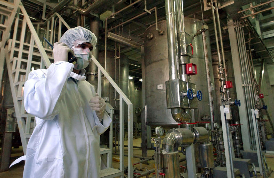 FILE - Wearing protective clothes, an Iranian security person, talks in a part of the Uranim Conversion Facility, prior to the arrival of then Iranian President, Mohammad Khatami, just outside the city of Isfahan, Iran, March 30, 2005. While the world’s attention has been focused on Ukraine, the Biden administration also has been racing forward with other global powers toward restoring the 2015 international nuclear deal with Iran. In Feb. 2022, after months of negotiations in Vienna, the various sides have indicated a new deal is close, perhaps in the coming days. (AP Photo/Vahid Salemi, File)