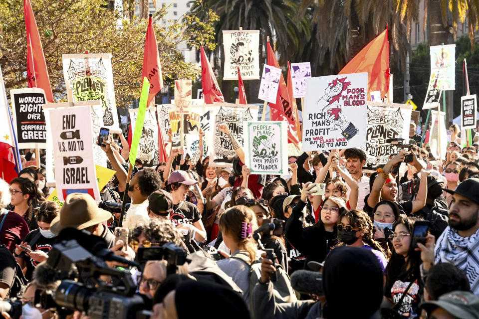 Demonstrators hold signs as they march in opposition to the APEC Summit Sunday, Nov. 12, 2023, in San Francisco. Hundreds of business executives, foreign press and world leaders will descend on San Francisco for the highly anticipated global trade summit. (AP Photo/ Noah Berger)