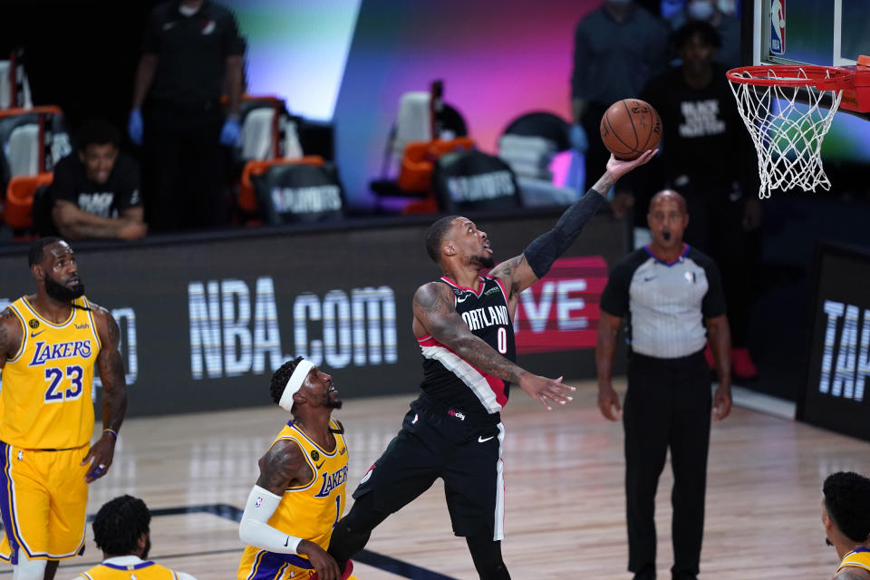 LAKE BUENA VISTA, FLORIDA - AUGUST 18:  Damian Lillard #0 of the Portland Trail Blazers goes to the basket over Kentavious Caldwell-Pope #1 of the Los Angeles Lakers during the first half in Game 1 of Round 1 of the NBA Playoffs at AdventHealth Arena at ESPN Wide World Of Sports Complex on August 18, 2020 in Lake Buena Vista, Florida. NOTE TO USER: User expressly acknowledges and agrees that, by downloading and or using this photograph, User is consenting to the terms and conditions of the Getty Images License Agreement. (Photo by Ashley Landis-Pool/Getty Images)