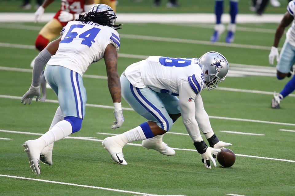 Dallas Cowboys defensive end Aldon Smith (58) picks up a fumble against the San Francisco 49ers in the first quarter at AT&T Stadium.