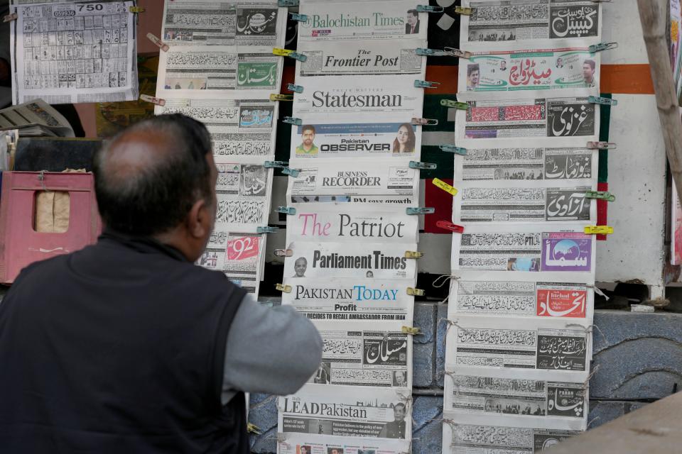 A Pakistani checks morning newspapers covering front page story of Iran's strike, at a stall in Islamabad, Pakistan, on Thursday.