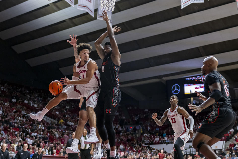 Alabama guard Mark Sears (1) tries to pass the ball by Mercer forward Amanze Ngumezi (8) during the first half of an NCAA college basketball game, Friday, Nov. 17, 2023, in Tuscaloosa, Ala. (AP Photo/Vasha Hunt)