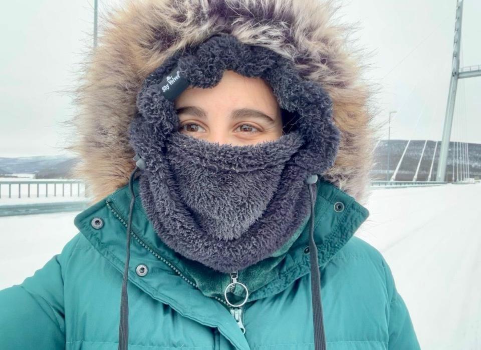 The author bundled up in a black fleece buff and green puffer jacket.