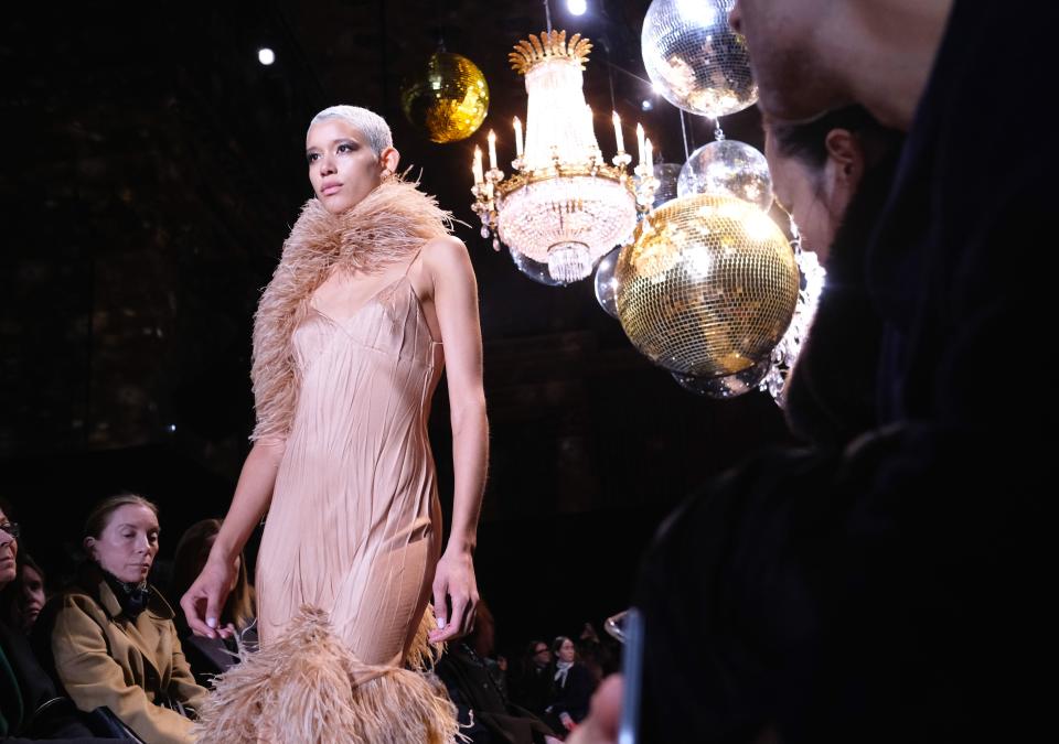 <p>The first clues were the disco balls hanging in between the chandeliers at Cipriani’s in downtown Manhattan. Michael Kors was going full-on disco for his fall 2019 collection, and the looks that followed-fluffy-collared wrap coats and slinky one-shouldered sequin dresses-were an on-the-nose ode to Studio 54. Fashion has long been obsessed with the ‘70s, but this season Kors doubled-down. </p><p>According to show notes, the Fall's Kors woman was a dancer on Broadway by day, and Studio 54 gal by night. For the former, there were wrap sweaters that looked plucked off the set of <em>Fame</em>, hooded bodysuits, fishnet tights, leg warmers, and all-around drapey layers. For the latter, sequin halter dresses and jumpsuits made for the dance floor, satin dresses with feather trim, and the kind of faux fur coat you’d need to top all your going-out looks. </p><p>Most shows end with a finale walk and a quick bow from the designer. But this is Michael Kors and the ‘70s were his era. Patti Hansen closed the show. And as the models started their finale walk, a sequin curtain in a corner of the space lifted to reveal Barry Manilow performing 'Copacabana' (which sounds as strange and amazing as it actually was). Unexpected at 10:30am, but after a week straight of shows it was a nice way to energize sleepy show-goers, this one included.</p>