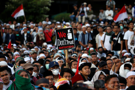 A protester holds a placard during a protest across the Election Supervisory Agency (Bawaslu) headquarters following the announcement of the last month's presidential election results in Jakarta, Indonesia, May 22, 2019. REUTERS/Willy Kurniawan