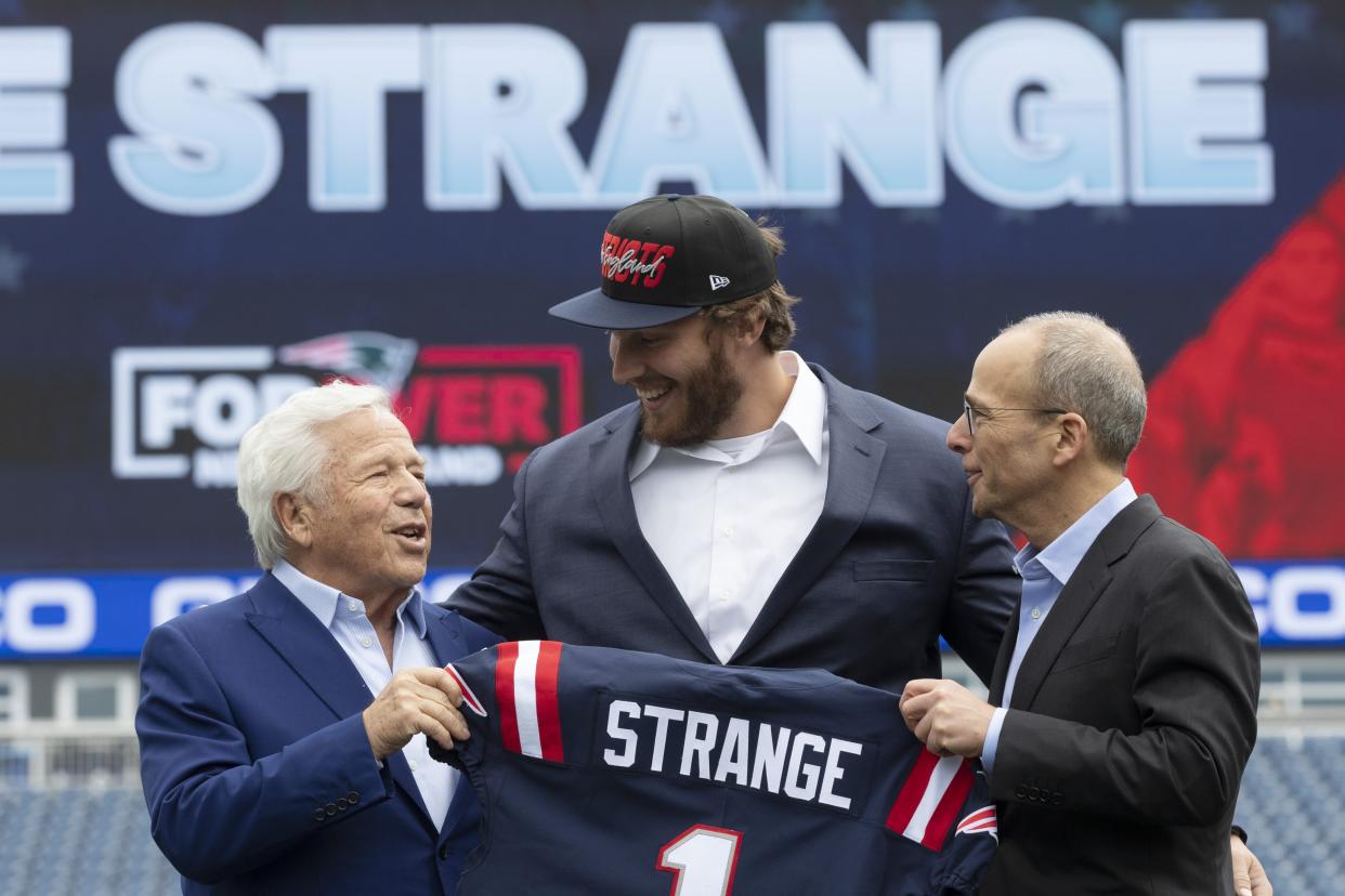 New England Patriots owner Robert Kraft, left, and Patriots president Jonathan Kraft, right, pose with first-round pick Cole Strange. (AP Photo/Michael Dwyer)