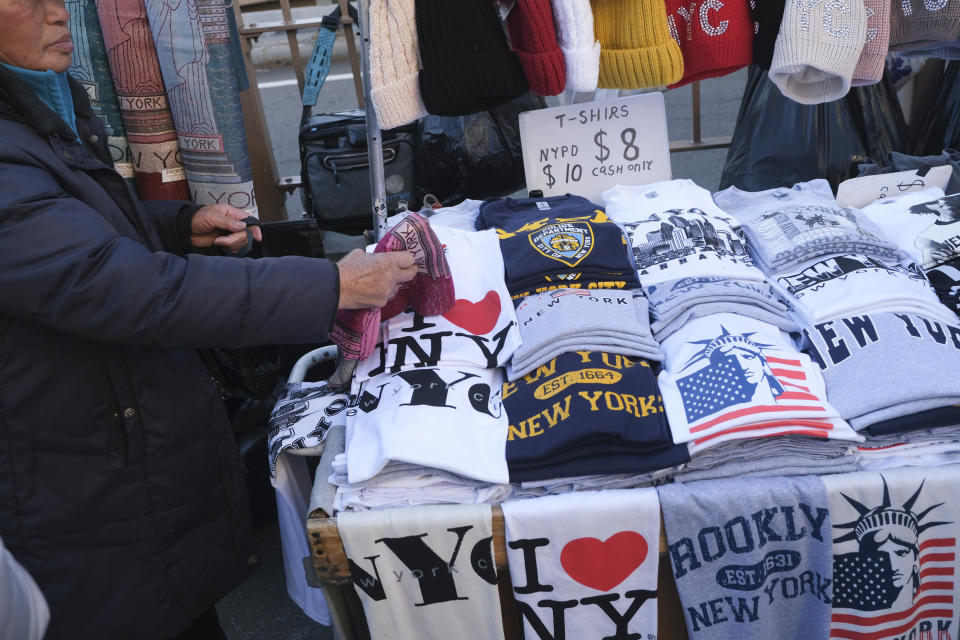 Vendors on the Brooklyn Bridge display their wares in New York, Tuesday, Jan. 2, 2024. New York City will ban vendors from the Brooklyn Bridge starting Wednesday, Jan. 3, 2024. The move is intended to ease overcrowding on the famed East River crossing, where dozens of souvenir sellers currently compete for space with tourists and city commuters. (AP Photo/Seth Wenig)