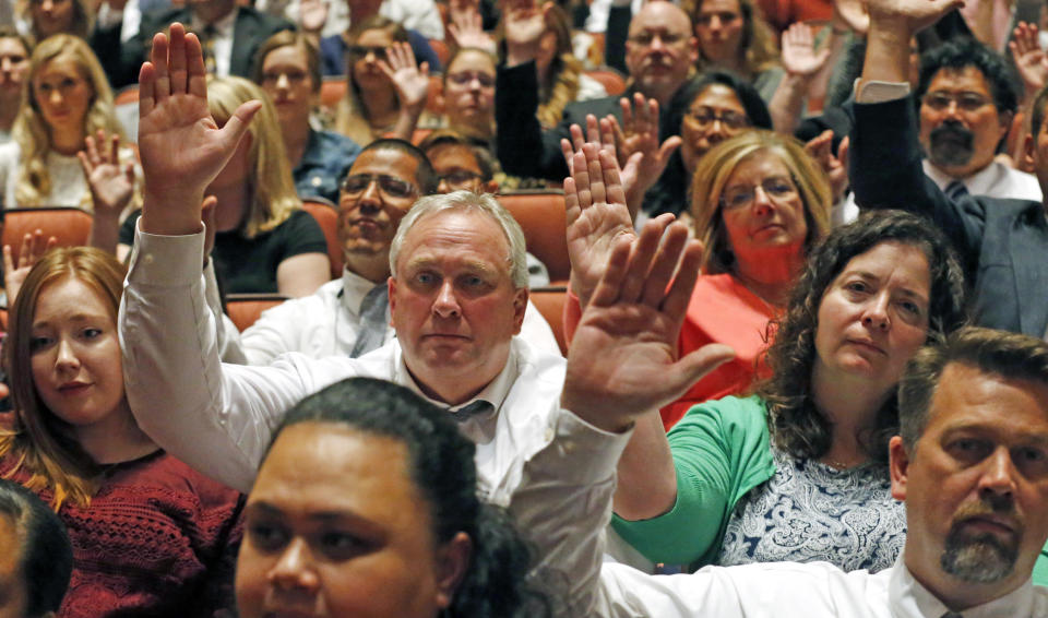 Mormons participate in a long-standing custom called a "sustaining" when Latter-day Saints stand and raise their hands during the twice-annual conference of The Church of Jesus Christ of Latter-day Saints, Saturday, Oct. 6, 2018, in Salt Lake City. (AP Photo/Rick Bowmer)