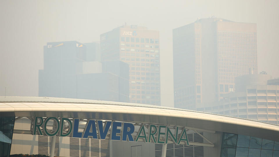 Rod Laver Arena with Melbourne city shrouded in smoke.