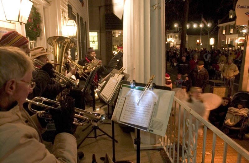 Night strollers enjoy the holiday sounds of The Brass Cosort at the Dickens Festival in the Medford Village section of Medford in this Courier Post file photo.