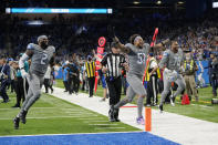 Detroit Lions linebacker Josh Woods (51) and linebacker Austin Bryant (2) run off the field after the second half of an NFL football game against the Minnesota Vikings, Sunday, Dec. 5, 2021, in Detroit. (AP Photo/Paul Sancya)