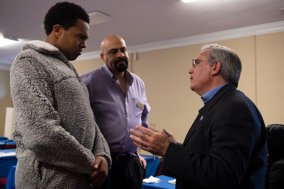 From right, Paul Merlo, an organizer for Tom Steyer, talks to Michael Forsyth and his son Brett during a "Get Out the Vote" party organized by the Greenville Democratic Black Caucus on Feb. 15.