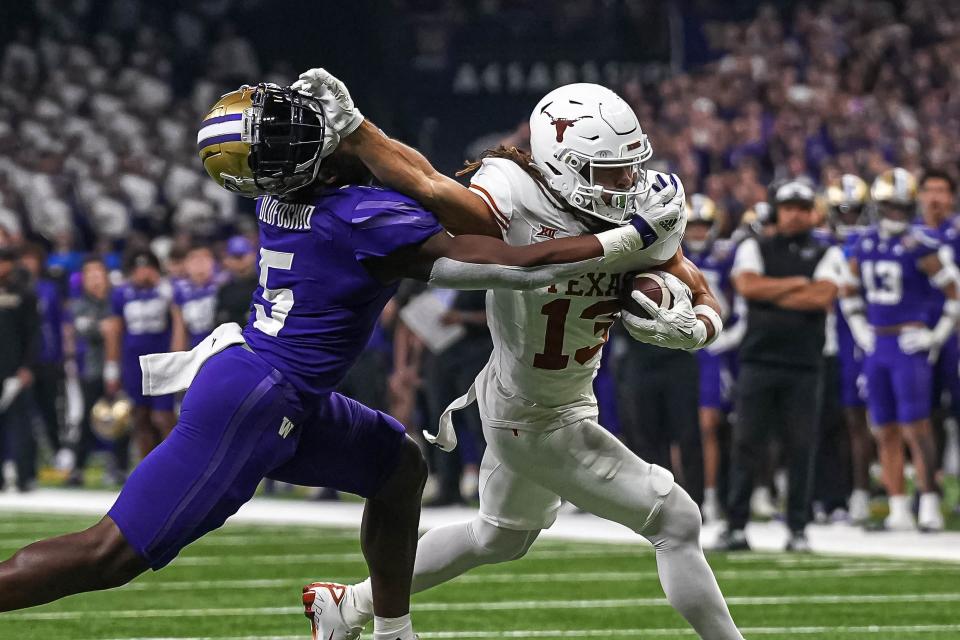 Texas Longhorns wide receiver Jordan Whittington (13) breaks a tackle by Washington linebacker Edefuan Ulofoshio (5) during the Sugar Bowl College Football Playoff semifinals game at the Caesars Superdome on Monday, Jan. 1, 2024 in New Orleans, Louisiana.