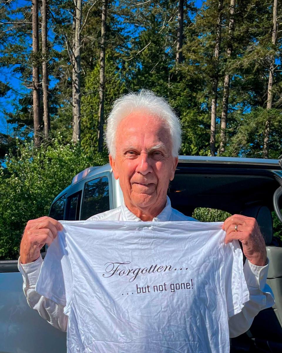 Brian Calder, chairman of the Point Roberts Chamber of Commerce, holds a shirt he made during the early days of the COVID pandemic when border closures isolated the small Washington state community completely bordered by Canada.