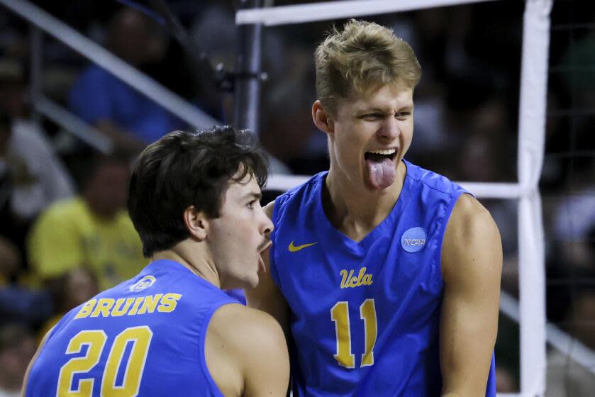 UCLA outside hitters Cooper Robinson (11) and Ethan Champlin (20) react during a match.