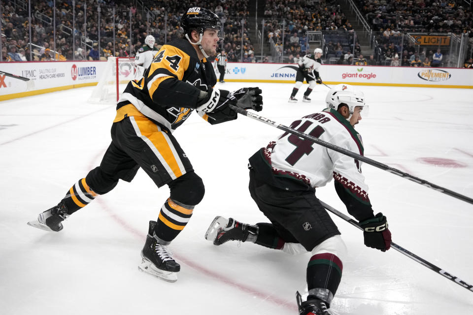 Pittsburgh Penguins' Jonathan Gruden (44) collides with Arizona Coyotes' Matt Dumba (24) during the second period of an NHL hockey game in Pittsburgh, Tuesday, Dec. 12, 2023. (AP Photo/Gene J. Puskar)
