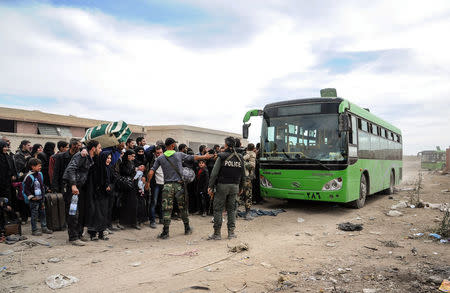 People are seen evacuated by Syrian forces from eastern Ghouta in Saqba, Syria, March 18, 2018. SANA/Handout via REUTERS