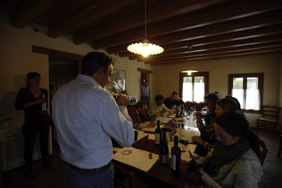 In this image taken on Monday, Oct. 15, 2018, wine grower Mirko Pizzobon explains organoleptic properties of a type of prosecco wine, during a wine tasting, at the Case Paolin farm, in Volpago del Montello, Italy. Global sales of prosecco the smooth, drinkable sparkling wine rooted in the northeastern hills of Italy are booming, and champagne, the original bubbly, is taking note. (AP Photo/Luca Bruno)