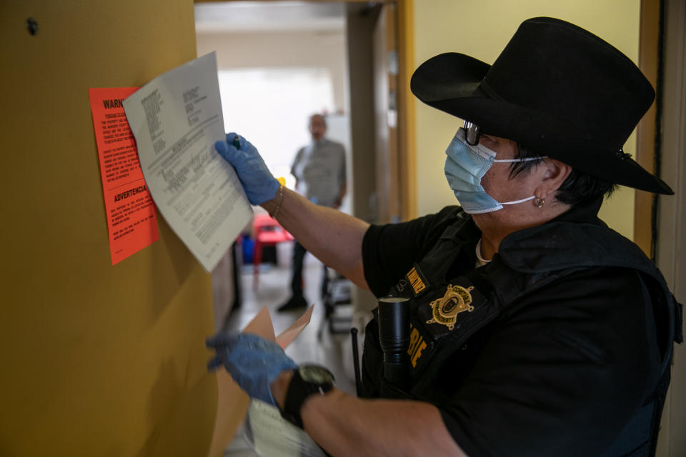 PHOENIX, ARIZONA - OCTOBER 01: Maricopa County constable Darlene Martinez posts an eviction order for non-payment of rent on October 1, 2020 in Phoenix, Arizona. Thousands of court-ordered evictions continue nationwide despite a Centers for Disease Control (CDC) moratorium for renters impacted by the coronavirus pandemic. Although state and county officials say they have tried to educate the public on the protections, many renters remain unaware and fail to complete the necessary forms to remain in their homes. In many cases landlords have worked out more flexible payment plans with vulnerable tenants, although these temporary solutions have become fraught as the pandemic drags on. With millions of Americans still unemployed due to the pandemic, federal rental assistance proposals remain gridlocked in Congress. The expiry of the CDC moratorium at year's end looms large, as renters and landlord face a potential tsunami of evictions and foreclosures nationwide.  (Photo by John Moore/Getty Images)