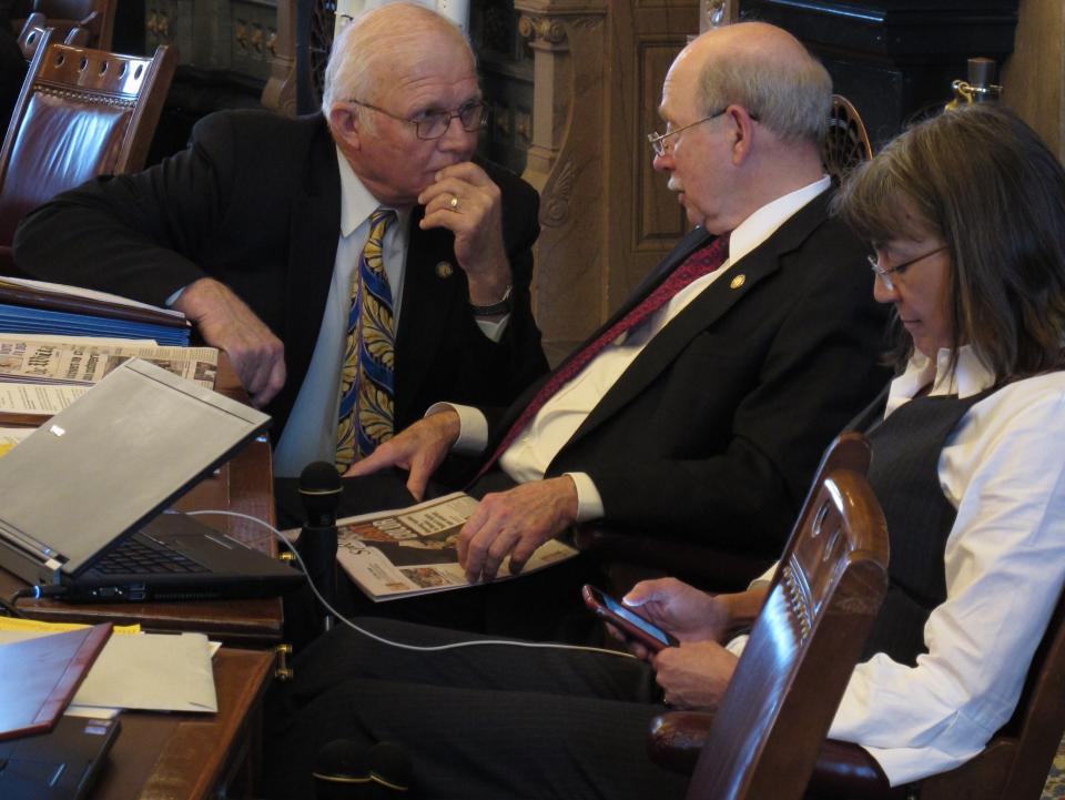 Kansas state Sen. Ralph Ostmeyer, left, a Grinnell Republican, consults with Senate Assessment and Taxation Committee Chairman Les Donovan, a Wichita Republican, center, during a debate on tax cuts, Tuesday, March 20, 2012, at the Statehouse in Topeka, Kan. To their right is Sen. Susan Wagle, a Wichita Republican. (AP Photo/John Hanna)