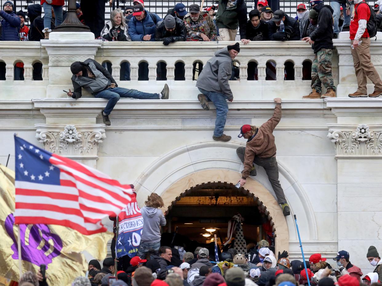 <p>A mob of supporters of former US President Donald Trump fight with members of law enforcement at a door they broke open as they storm the US Capitol Building in Washington, DC, on 6 January 2021</p> ((Reuters))