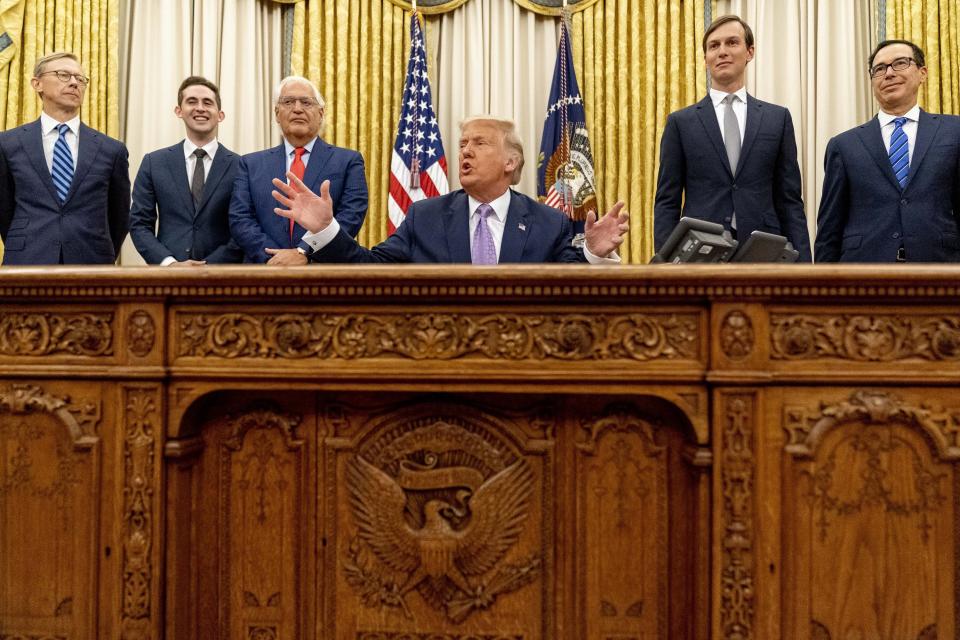 President Donald Trump, accompanied by from left, U.S. special envoy for Iran Brian Hook, Avraham Berkowitz, Assistant to the President and Special Representative for International Negotiations, U.S. Ambassador to Israel David Friedman, President Donald Trump's White House senior adviser Jared Kushner, and Treasury Secretary Steven Mnuchin, speaks in the Oval Office at the White House, Wednesday, Aug. 12, 2020, in Washington. Trump said on Thursday that the United Arab Emirates and Israel have agreed to establish full diplomatic ties as part of a deal to halt the annexation of occupied land sought by the Palestinians for their future state. (AP Photo/Andrew Harnik)