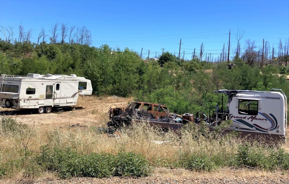A burned-out trailer and vehicle remain in a field in Keswick, where neighbors have complained recently of building code violations.