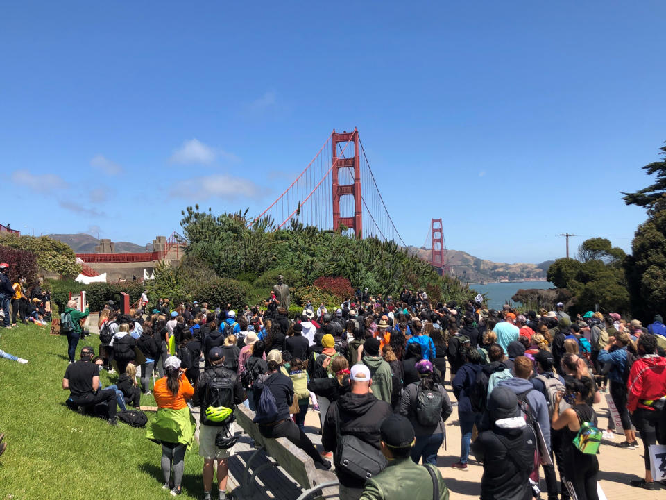 Dozens of people gather by the Golden Gate Bridge Welcome Center in San Francisco Saturday, June 6, 2020, to begin marching across the famous span in support of the Black Lives Matter movement. (AP Photo/Jeff Chiu)