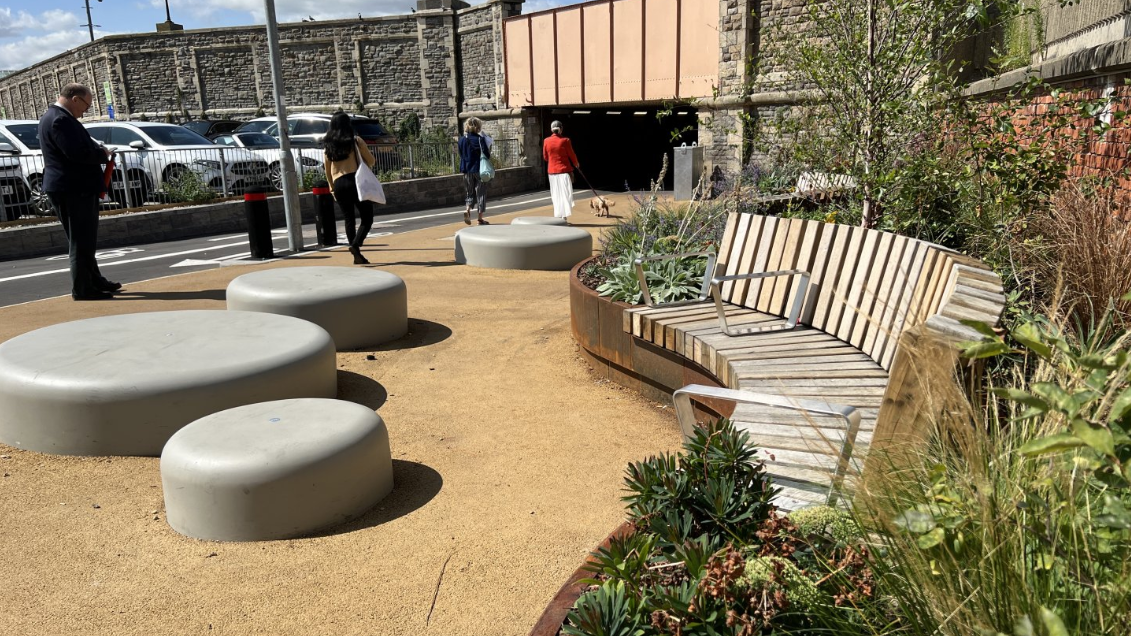 A small park with planting and seating outside the renovated underpass