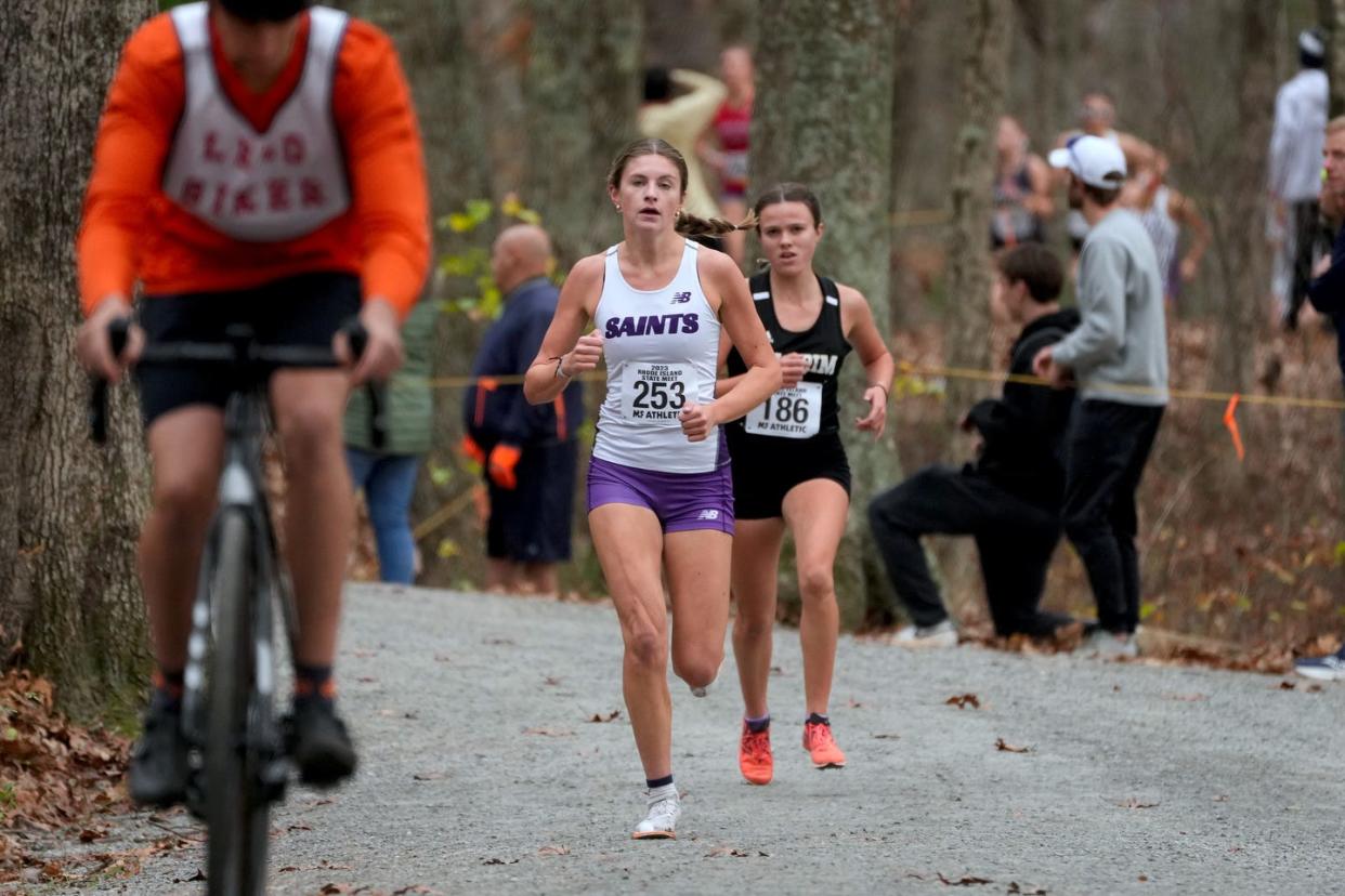 St Raphael Academy Saint Rory Sullivan leads Keaney Bayha of Pilgrim through the woods. Sullivan finished first for the girl.