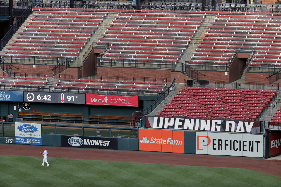 St. Louis Cardinals catcher Yadier Molina warms up in front of empty seats before the start of an opening day baseball game against the Pittsburgh Pirates Friday, July 24, 2020, in St. Louis. (AP Photo/Jeff Roberson)