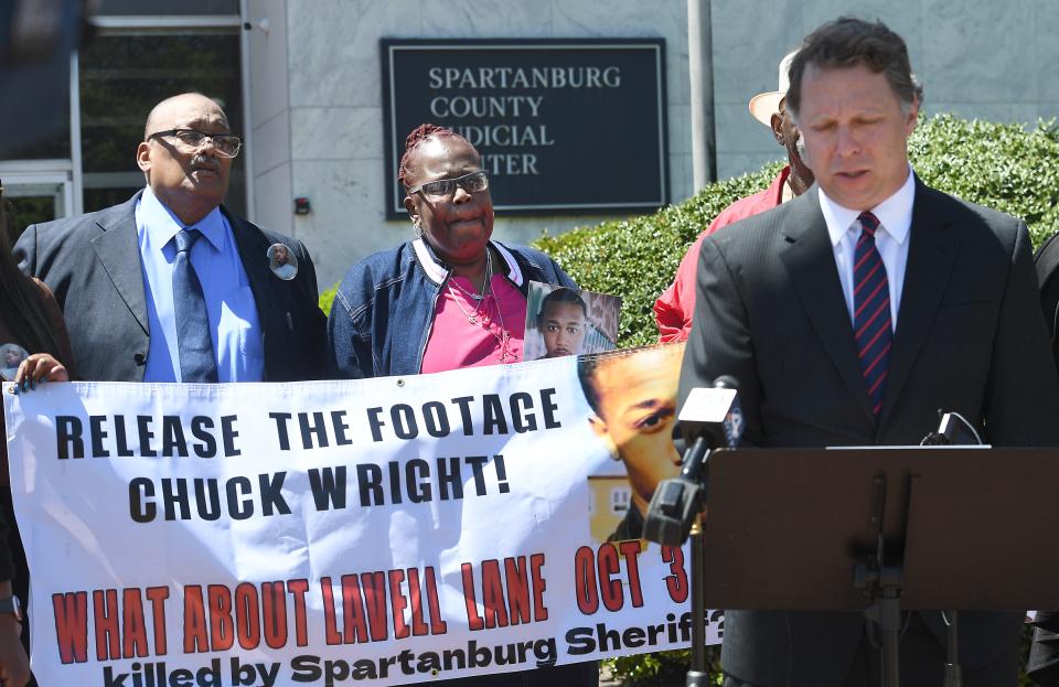 The parents of Lavell Lane, Andy Reese and Beverly Reese Lane filed civil charges against Spartanburg County and the Spartanburg County Sheriff's Office on April 17, 2023.  Lavell Lane died in custody at the Spartanburg County Detention Center. Andy Reese and Beverly Reese Lane, left, hold a banner asking that the footage at the detention center of their son be released as their lawyer, Christopher Pracht, right, talks about the charges filed.
