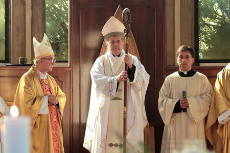 Bishop Juan Barros (C) attends his first religious service as citizens (not pictured) protest against him at the Osorno cathedral, south of Santiago, Chile March 21, 2015. Picture taken March 21, 2015. REUTERS/Carlos Gutierrez