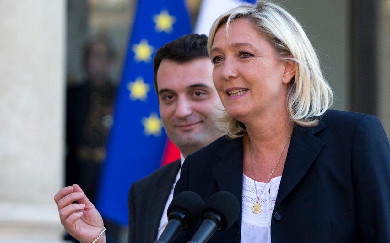 French far-right Front National Party President Marine Le Pen and vice-president Florian Philippot, left, talk to the media at the Elysee Palace, in Paris in May 2014 - AP