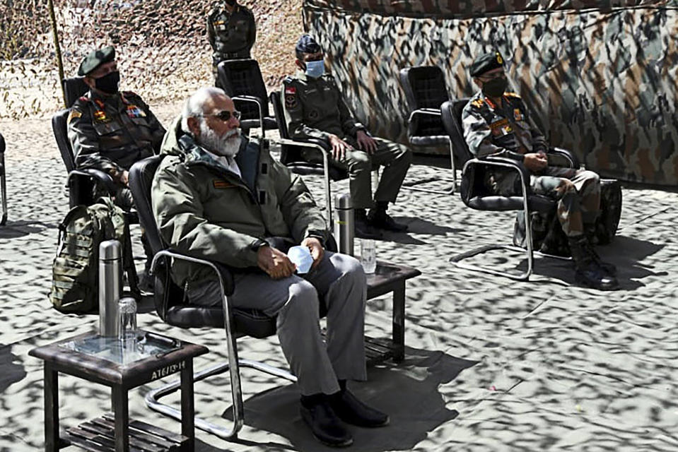 India's Prime Minister Narendra Modi (L) sits during a briefing with military commanders as he arrives in Leh, the joint capital of the union territory of Ladakh. (Photo by Handout / PIB / AFP)